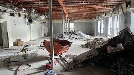Renovations in the Innovation Building. Photo shows demolition of concrete and wheel barrow