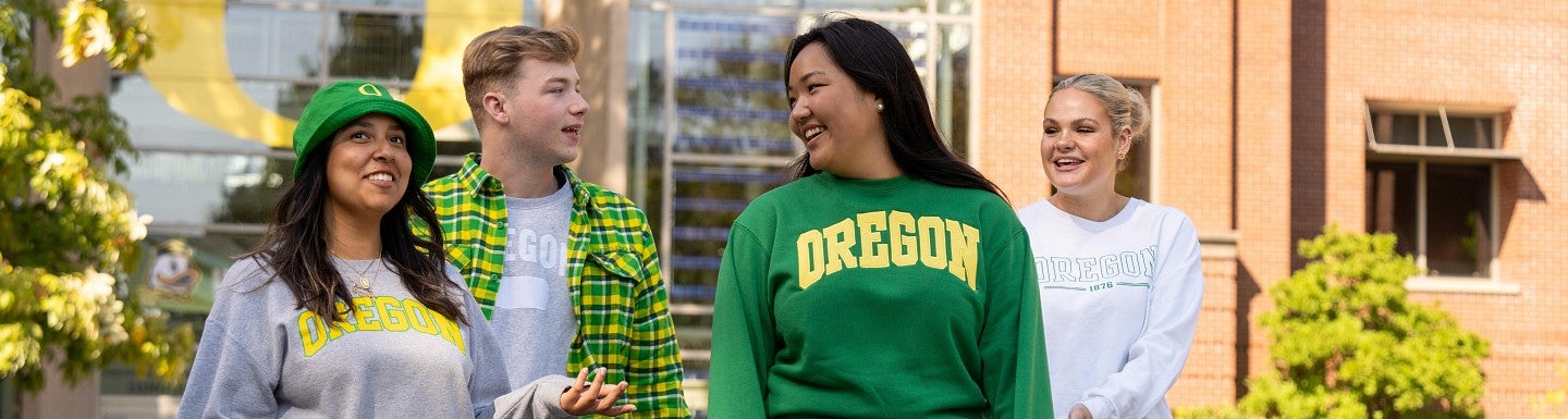 UO students wearing UO gear walk outside Lillis Hall