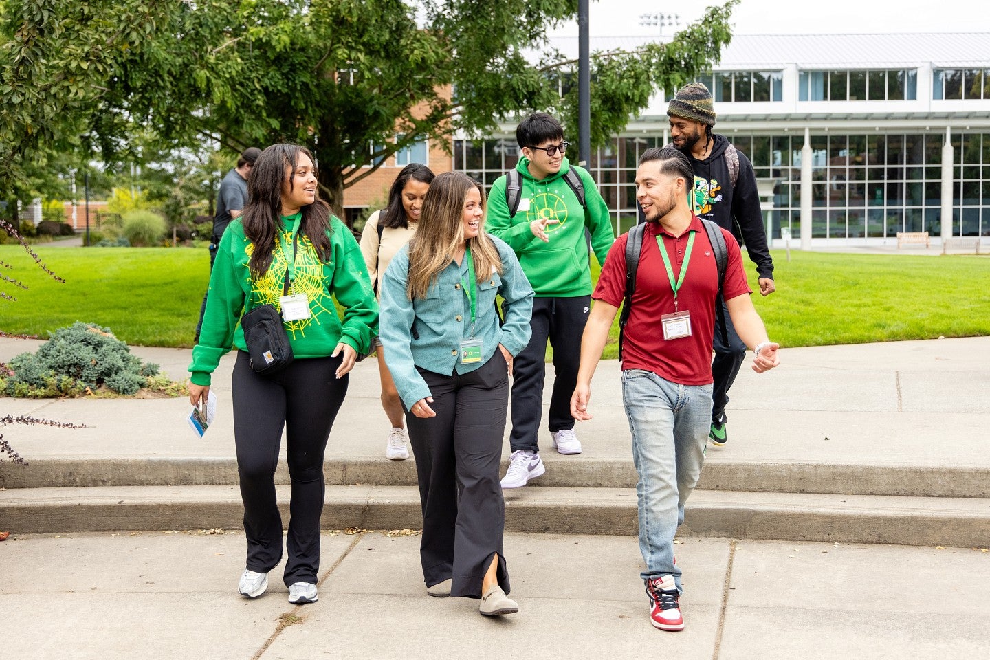 Students walk in a group across the campus green