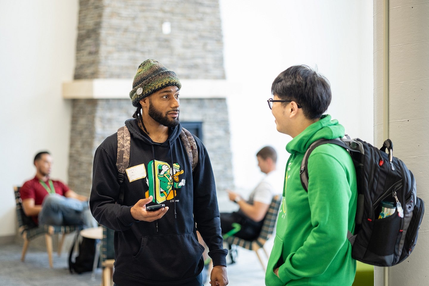 two students stand in a foyer and talk