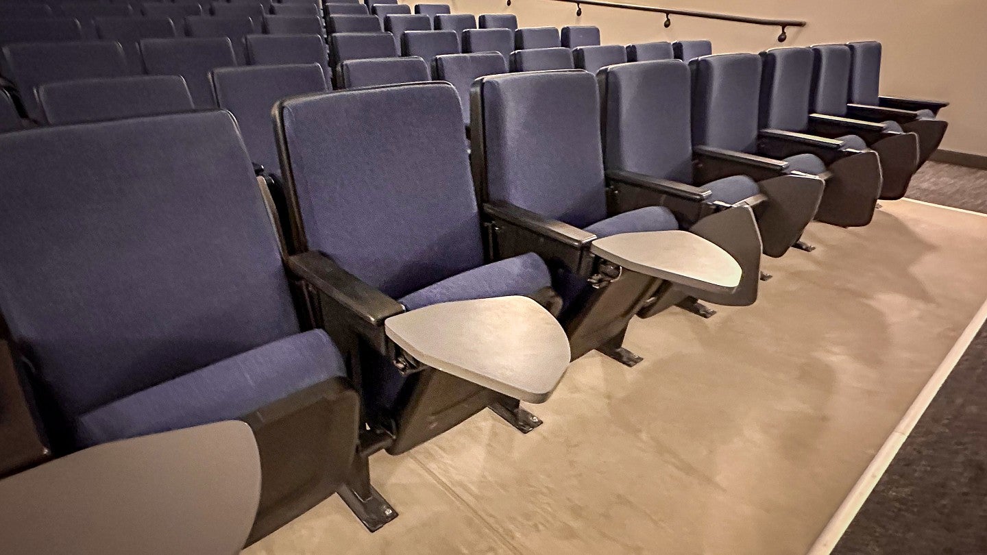Seats in the auditorium include flip up writing desks.