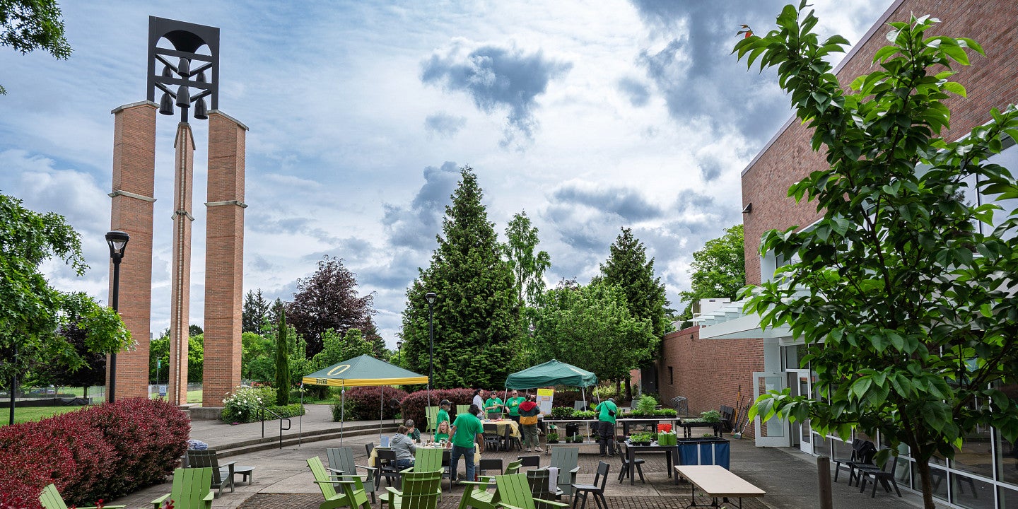 People on the Campus Center patio with the Bell Tower.