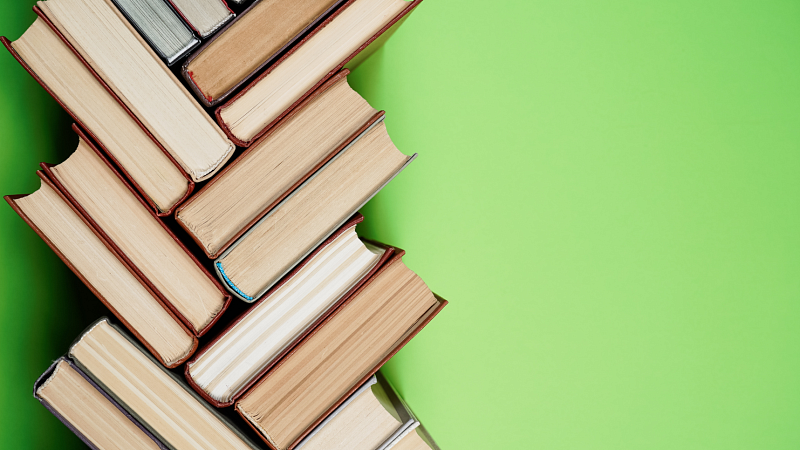 textbooks stacked in a geometric pattern on a green background