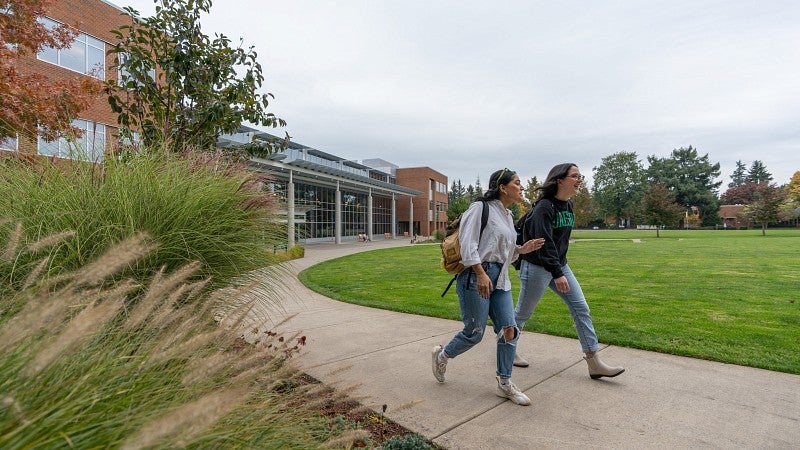 Two UO students walk on campus