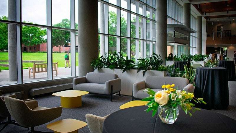 Alumni Atrium with couches and chairs that look out over a green space