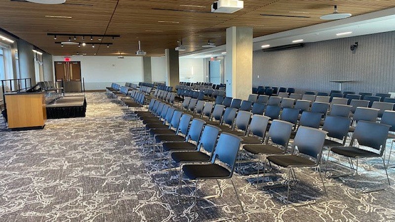 Confluence Community Room set with rows of chairs in front of stage and lectern.