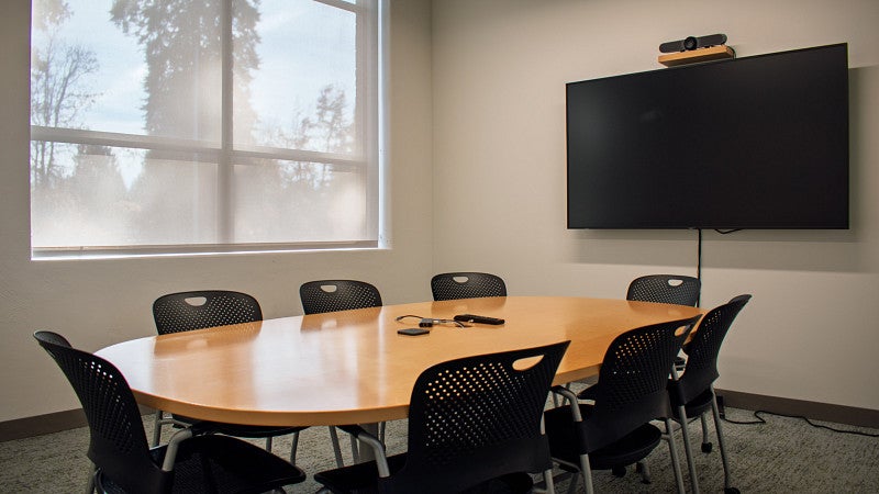 Conference room with screen and large window.