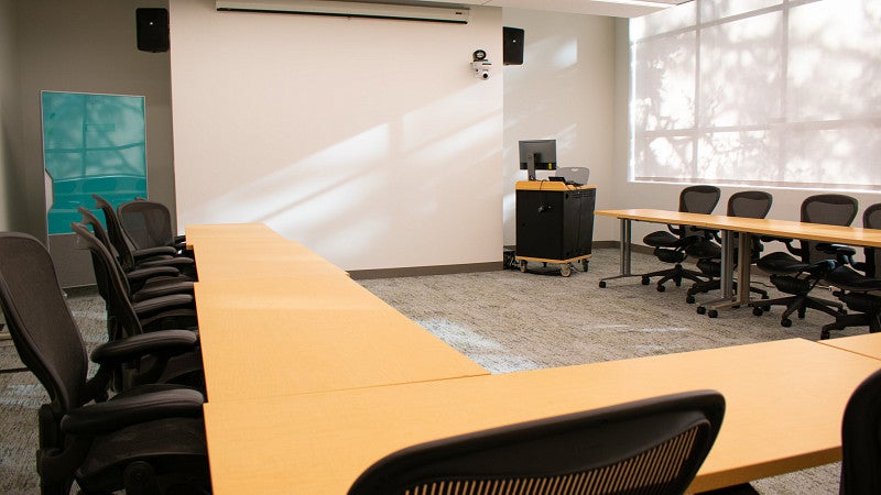 Innovation classroom includes a large screen and glass dry-erase board. 