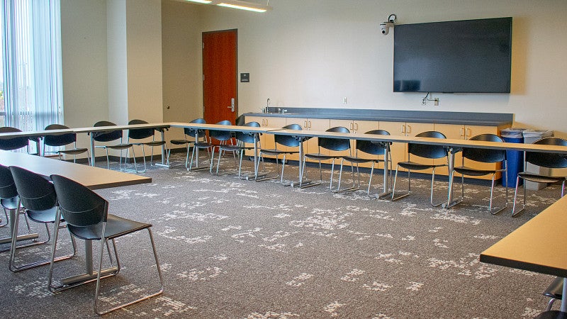 There are multiple display screens and a large window in the room. 