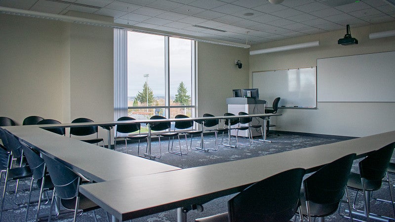 The room includes multiple screens and white boards.