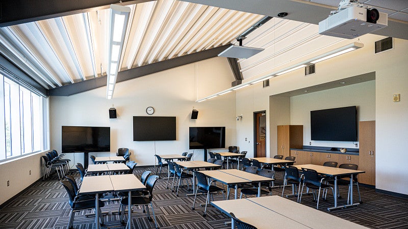 The classroom has several large screens around the room.