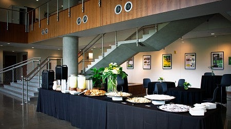 A buffet table with food and flowers next to a staircase. 