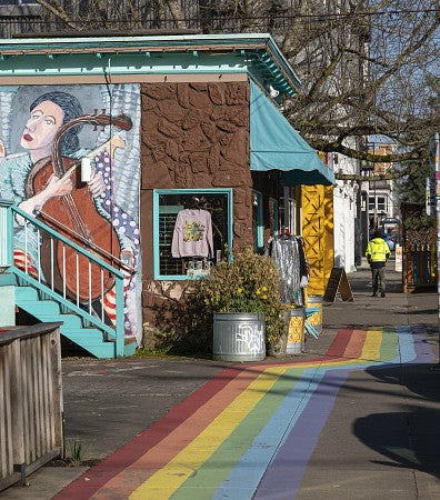 Alberta Street with shops, murals and a rainbow painted on the sidewalk.