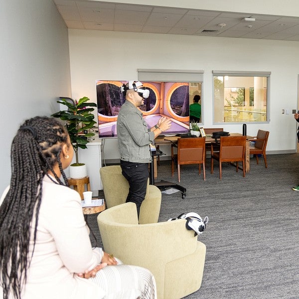 students stand in The Duck Nest. A man wears a VR headset