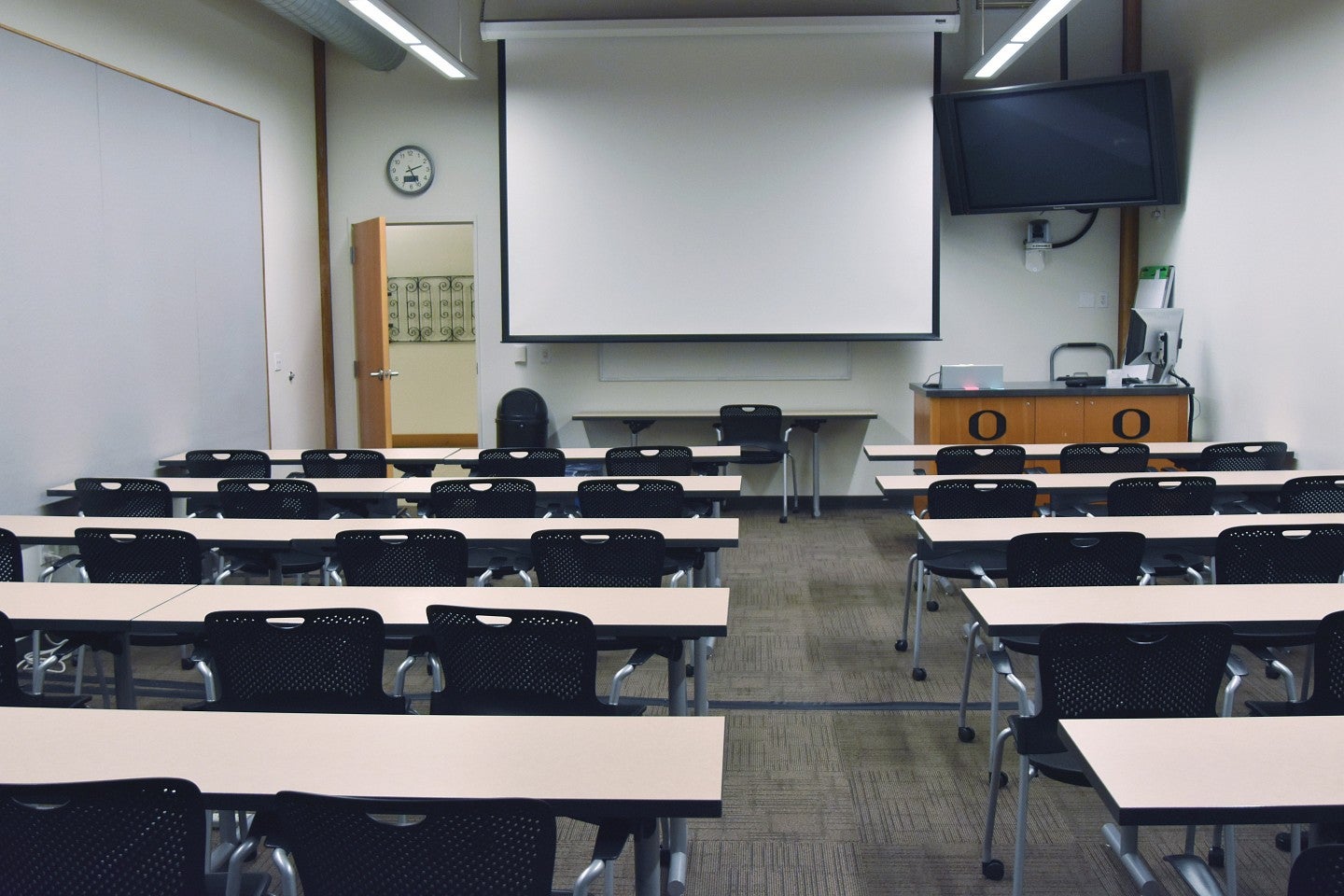 Classroom 152 Classroom 152 with desks and a big projector screen.