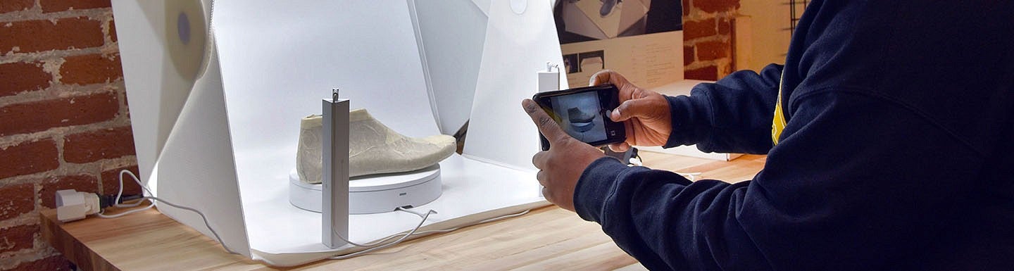 A student takes a photo of a shoe being designed in the Sports Product Management innovation lab.
