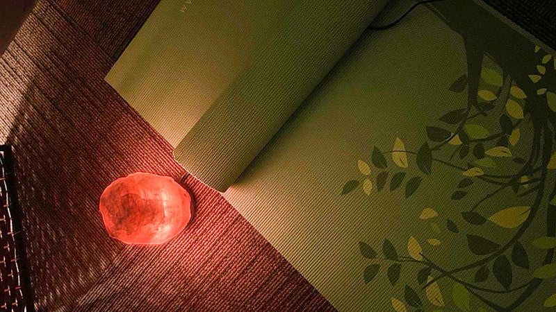 yoga mat and himalayan salt lamp rest on the floor of the Mindfulness Room