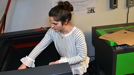 A student uses a laser printer in the fabrication lab